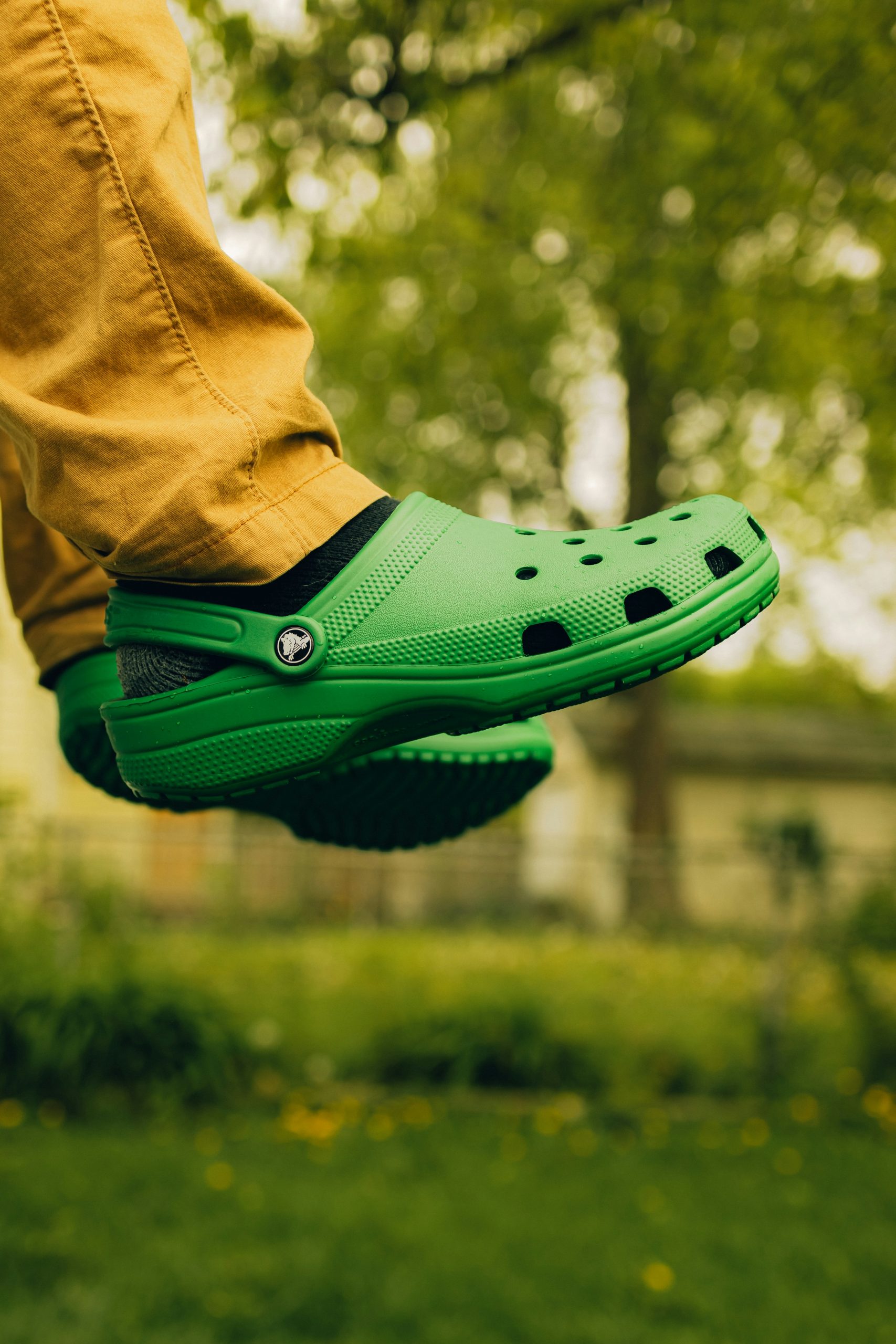 Classic black Crocs by a bed or coffee machine